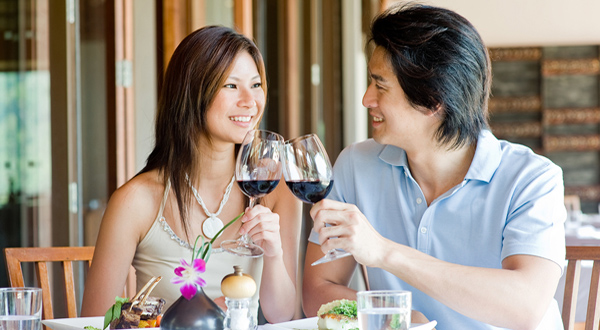 Asian couple clinking wine glasses on vacation